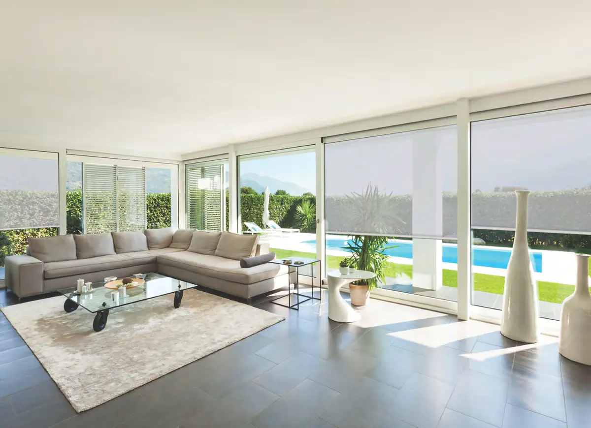 Sheer screen blinds drawn against a garden and pool